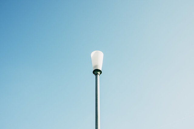 Detail view of broken street lamp without roof against blue sky