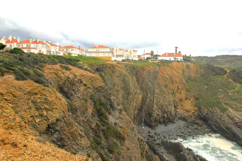 The colourful houses of Zambujeira do Mar perched on the cliff edge