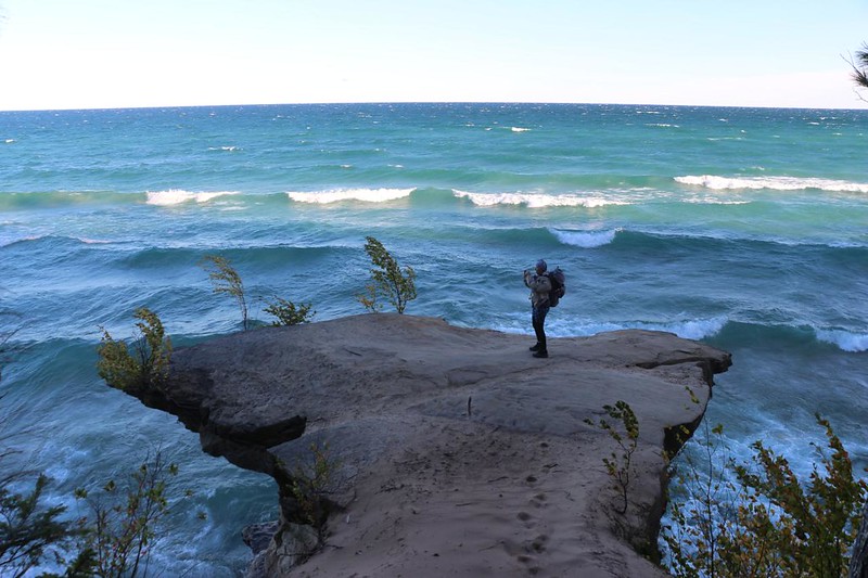 Vicki on the sandstone spit as she took pictures on a rough and windy day on Lake Superior