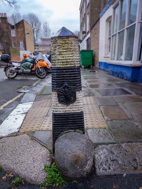 Camden, Camden Town, Carol Street: bollard and spur stone wheel guard