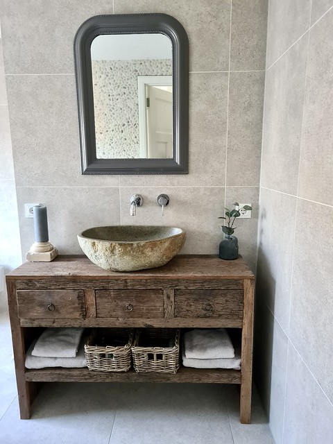 Landelijke badkamer waskom riviersteen kuifspiegel houten badmeubel met rieten manden