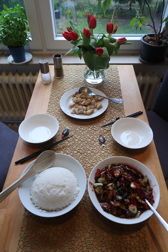 Wok-Pfanne mit Reis und Fischstücken (Tischbild)