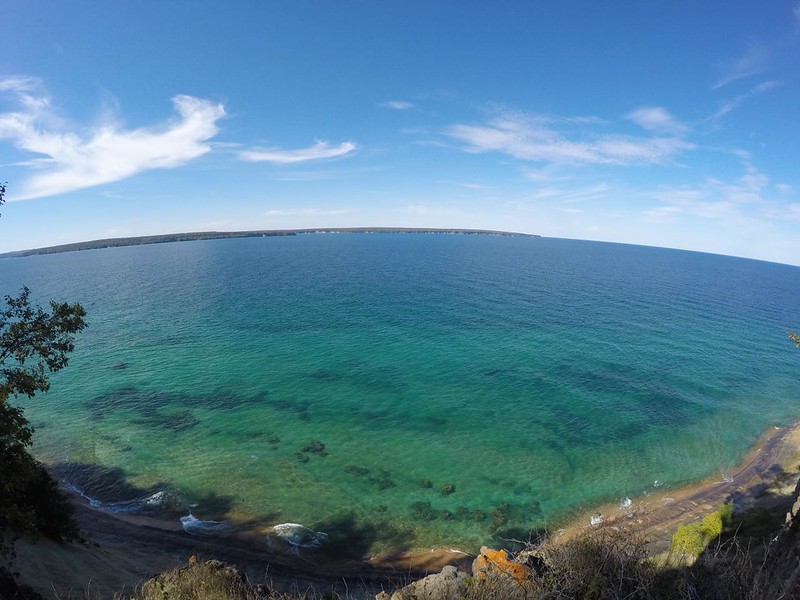Wide angle GoPro photo of Lake Superior on a calm day, with Grand Island across the way, on the North Country Trail