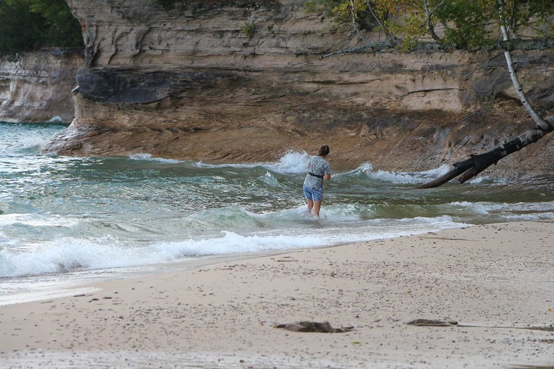 Vicki wading in Lake Superior, trying to get a good photo of Chapel Rock, in Pictured Rocks National Lakeshore