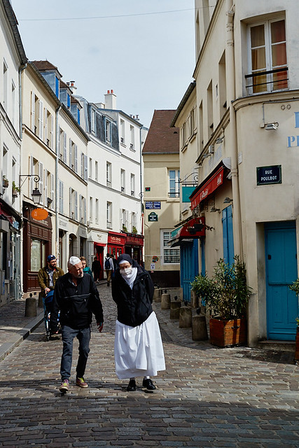 Muslim man ans catholic nun walking togethe in Montmatre, Paris, France