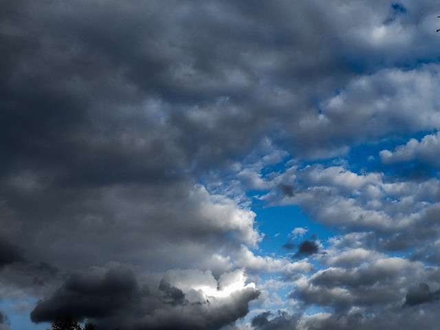 Explore - Blue sky through dark clouds