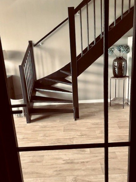 Zwarte trap in woonkamer met zwart stalen deuren