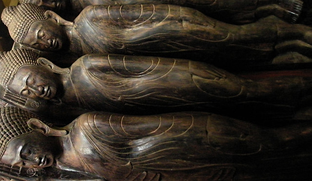 Stacks of wooden reclining Buddhas in a temple in Cambodia