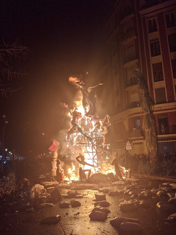 Bright, orange glow of the burning Falla in the middle of the dark street.