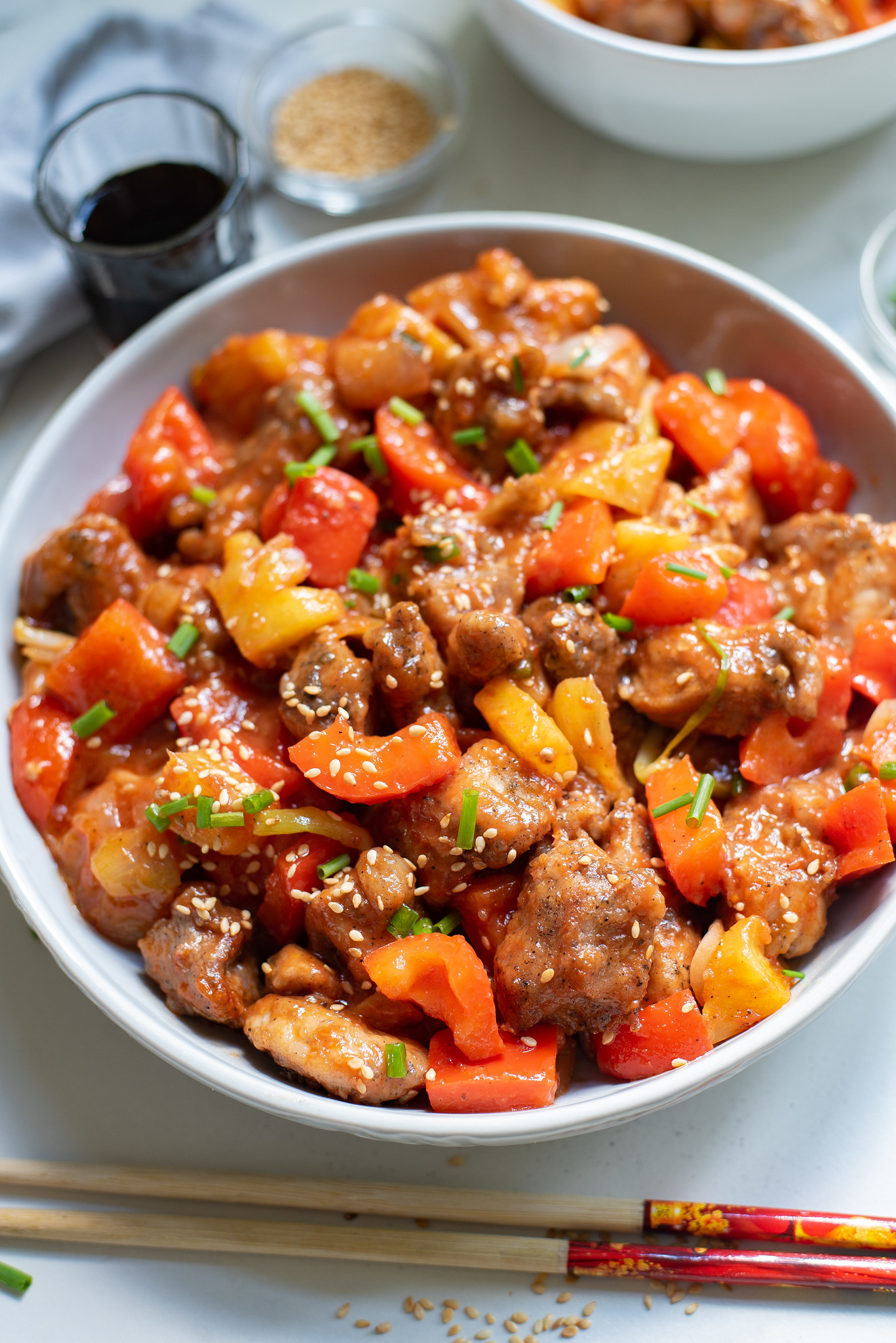 A big bowl of sweet and sour pork with bell peppers, onions, and pineapple