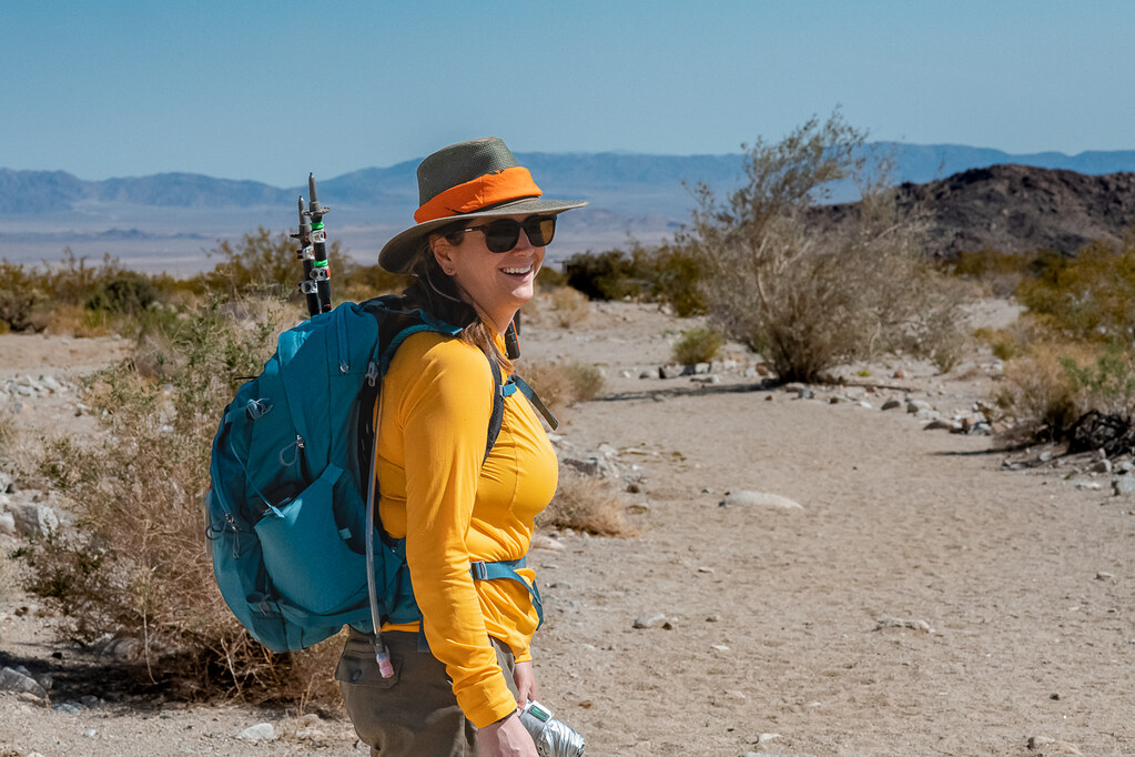 Hiker wearing sun hat, sunglasses, and protective clothing in Joshua Tree desert