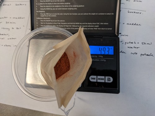 Ground powder in bag on scale that reads 493g