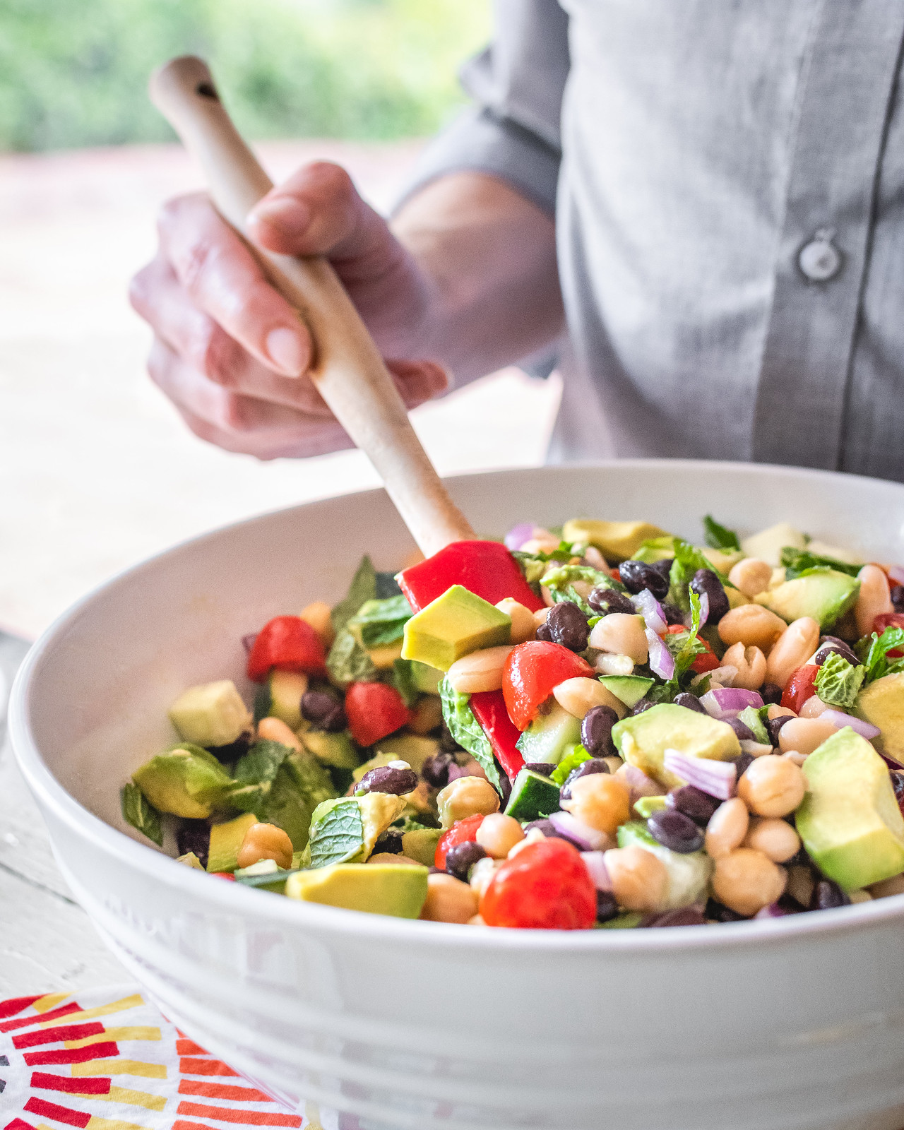tossing a bowl of colorful chopped salad