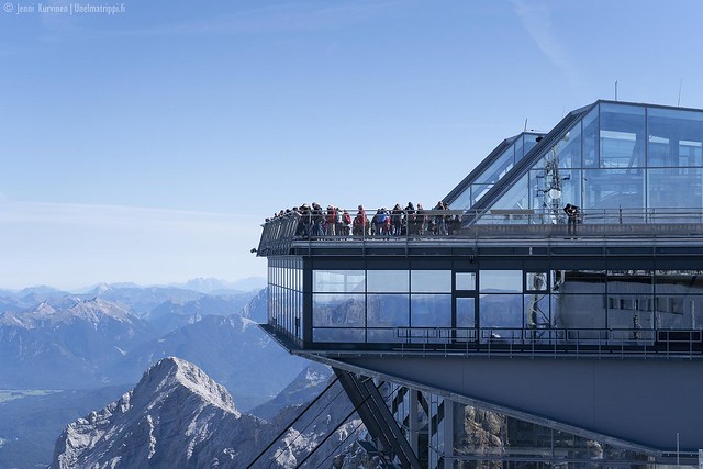Ihmisiä näköalatasanteella lasisessa rakennuksessa Zugspitzen huipulla