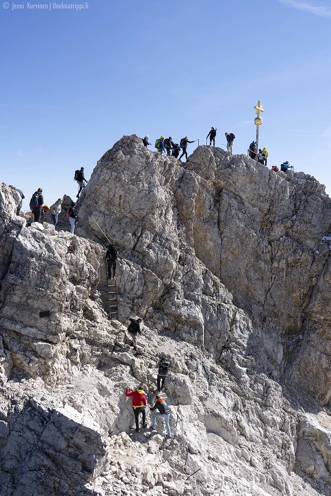Ihmisiä kallionseinämällä kapuamassa Zugspitzen vuorenhuippuristille