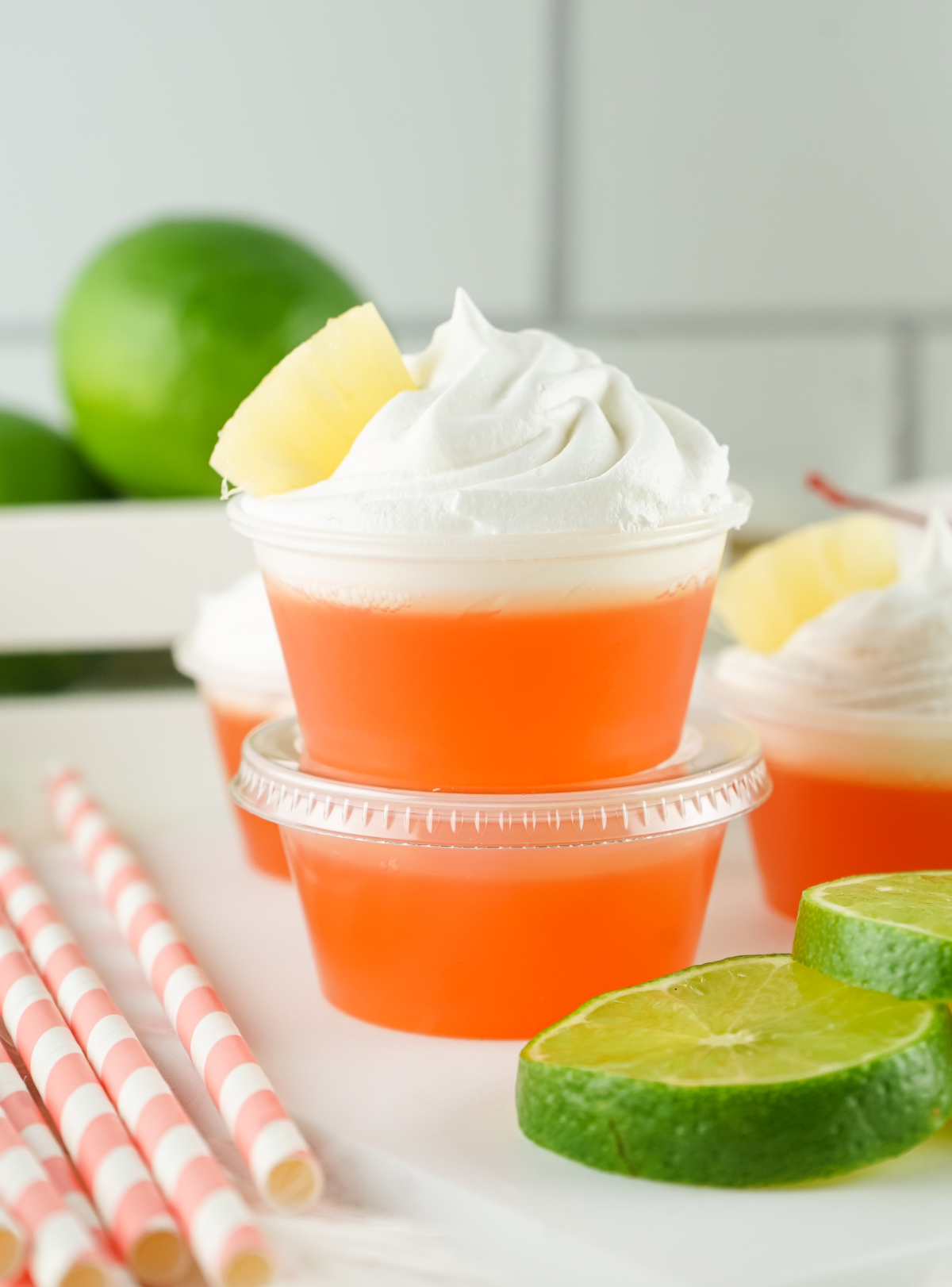 Tropical rum jello shots with whipped cream and a pineapple chunk on top