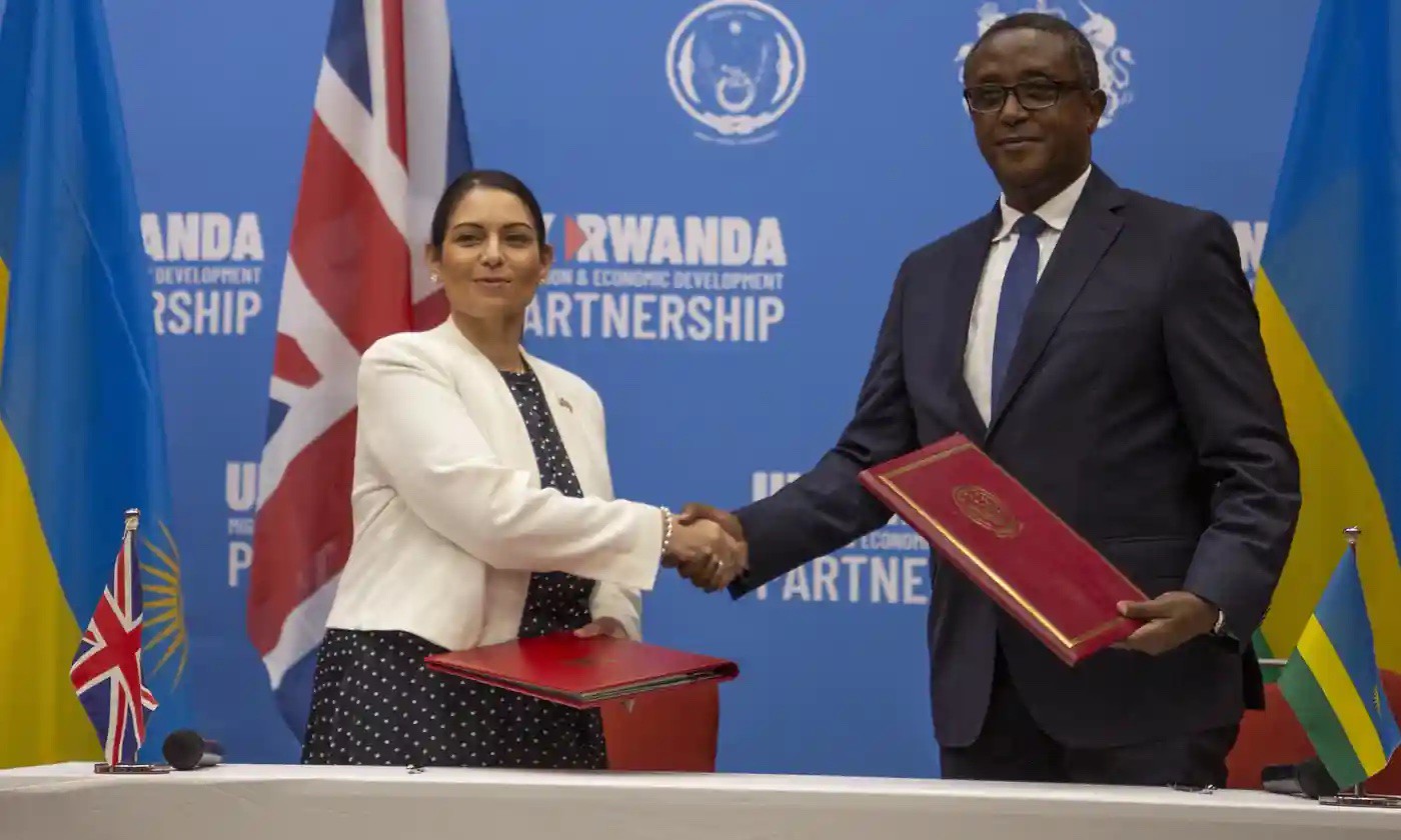 英國內政大臣帕特爾（左）與盧安達外交部長比魯塔簽訂難民外包協議。（圖片來源：衛報）