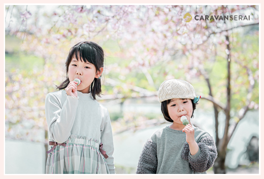 花より団子！　桜咲く公園でお団子を食べる姉妹
