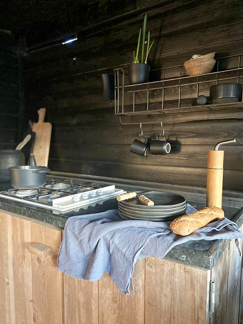 Buitenkeuken landelijke stijl linnen doek grijze borden grote houten pepermolen mokkenrek
