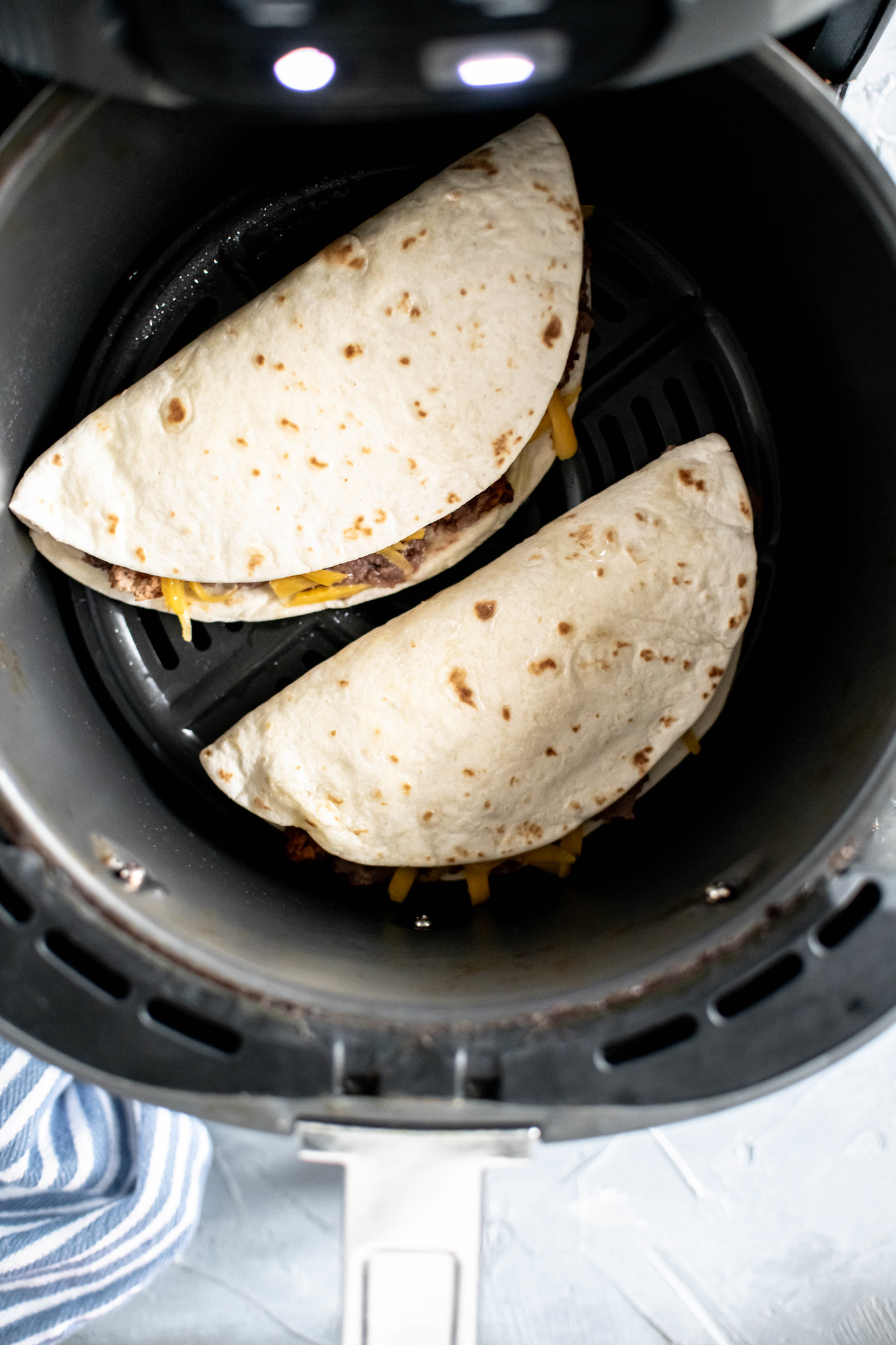 Two tacos in the air fryer.