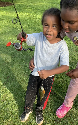 Photo of young boy holding a fish caught on his line