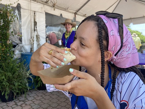 WWOZ volunteer Kendra enjoying a new Jazz Fest food item: fish taco from Carmo at Jazz Fest - May 7, 2022. Photo by Carrie Booher.