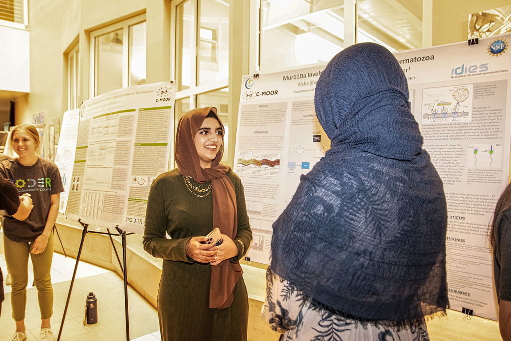 A student shares her poster at the Annual Clovis College Research Symposium