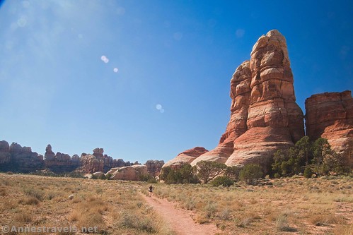 A hiker below a spire in Chesler Park, Needles District, Canyonlands National Park, Utah