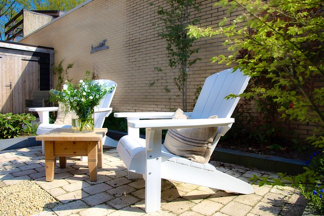 Witte houten lounge tuin stoel houten salontafel met vaas met bloemen