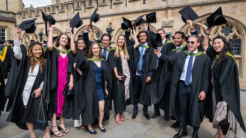 Students celebrating at their graduation ceremony outside Bath Abbey