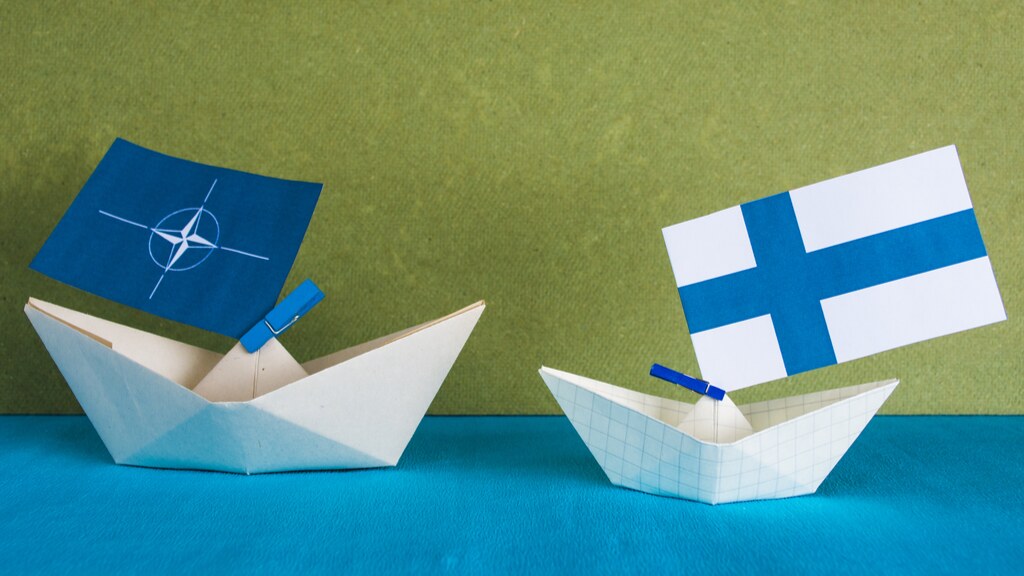 A photo of paper ships with the NATO and Finland flag