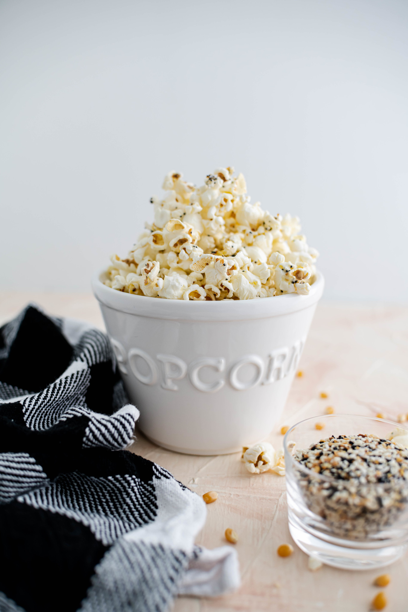 Ceramic popcorn bowl filled with everything bagel popcorn.