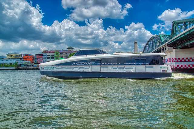 Passenger Ferry passing Memorial bridge on the Chao Phraya river in Bangkok, Thailand