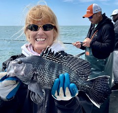 Photo of woman holding a black sea bass