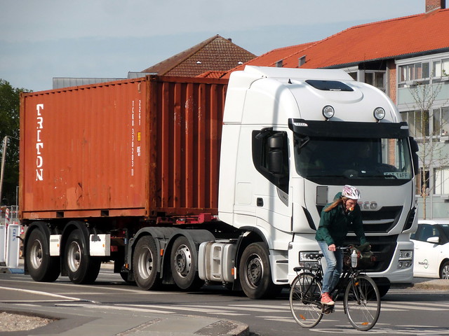 Apple gagging cyclist photobombs Iveco truck hauling shipping container