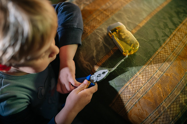 Boy make believe fixing a battery torch with toy pliers
