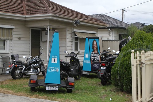 'Vote 1 Dr Monique Ryan for Kooyong 2022' advertising signs hooked up behind motor scooters