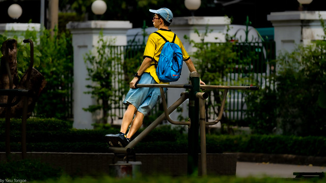 Kid exercising on a swing,  Benchasiri Park, Bangkok, Thailand.  643