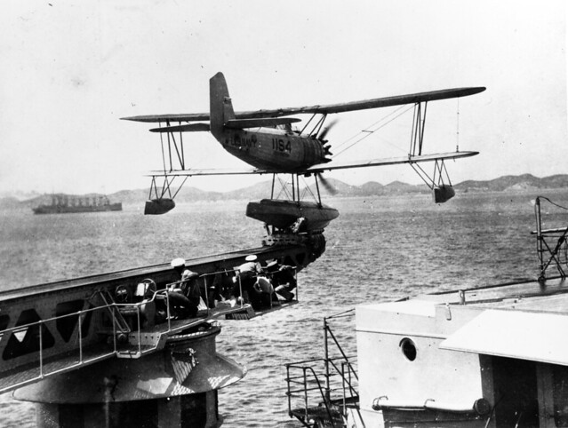 Vought O2U-3 or O2U-4 Corsair floatplane, of Scouting Squadron Eleven Is catapulted from USS Houston (CA-30), in Far Eastern waters, (circa 1931-1932). USS Jason (AV-2) is in the left distance.