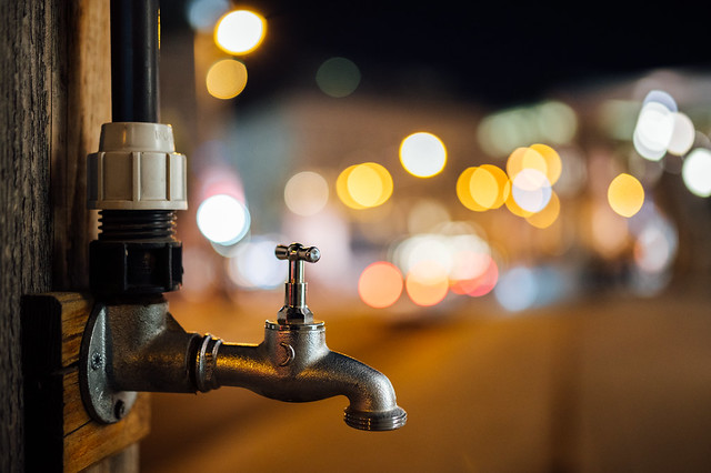 Old faucet and city lights in the background