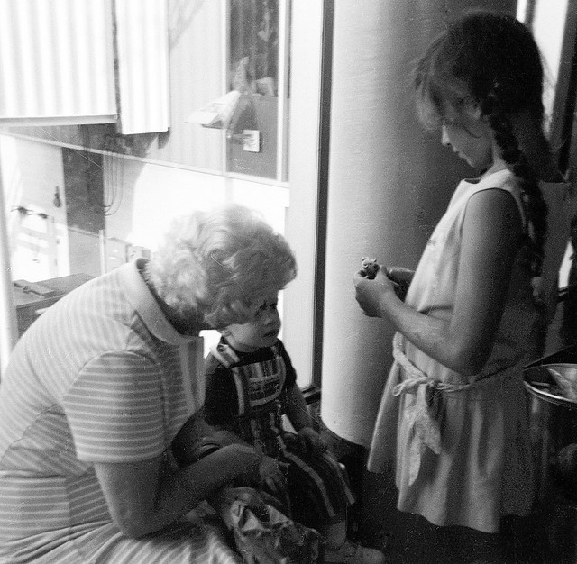 While waiting for our Los Angeles cousins to arrive at JFK airport, my sister comforts a little boy who was petrified of flying with a little toy mouse she kept in her purse. Queens, New York. July 1972.