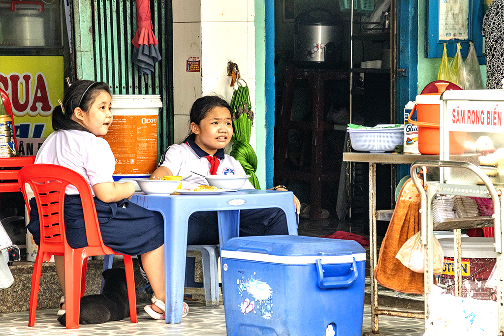 Two schoolkids snacking at 11 43AM on 5-26-22--Vung Tau copy