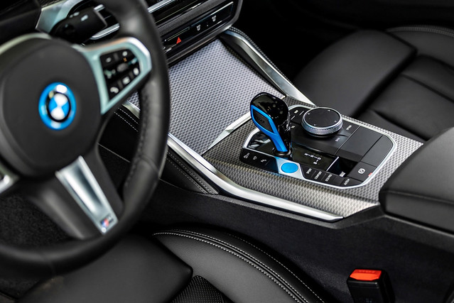 [新聞照片七] BMW i4於座艙內多處細節展現專屬於電能的設計與巧思，如中央鞍座區塊專屬藍色啟動鈕、排檔桿與方向盤上方專屬藍色飾板等處