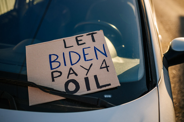 Sign with text 'Let Biden Pay 4 Oil' left behind the windshield wiper