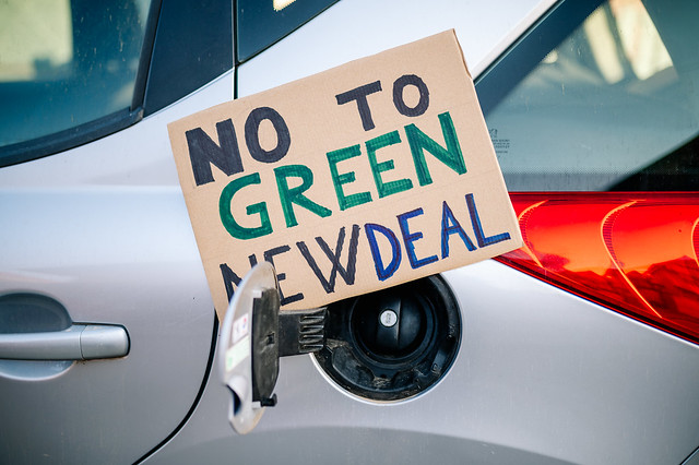 Sign with text 'NO to green new deal' left on a car's open fuel door