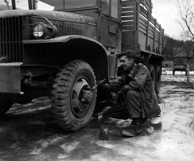 SC 374721 - The paint job on the wheel of this First Army truck is touched up by Pfc. Lawrence J. Morris, 3449 Marshall Road, Upper Darby, Pa., 83rd Quartermaster Depot, 83rd Infantry Division.