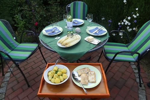 Steinbeißerfilets, Salzkartoffeln und Butter zum Spargel (Tischbild im Garten)