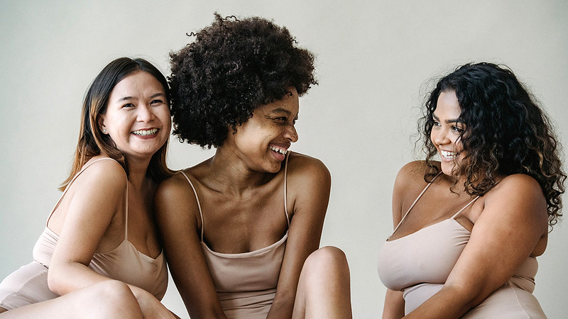 Three women relaxing together and smiling.