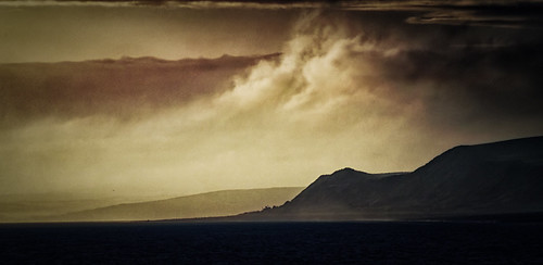 Port William Sunset by Andrea Beeson, Taken at sunset from Port William, Scotland. I liked the clouds rolling in lit by the sun and contra