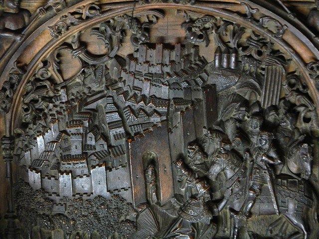 A wood carving with a view of the city in the interior of Toledo Cathedral in Spain